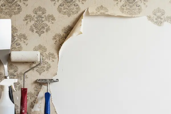 Ferramentas para como remover papel de parede antigo e parede preparada para nova decoração.